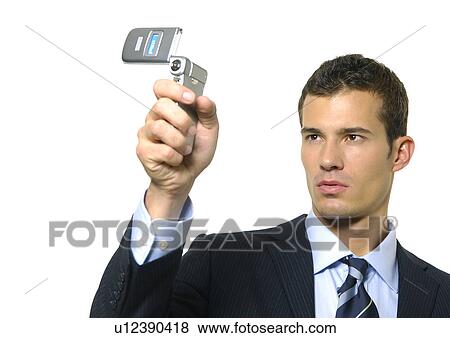 Stock Photo - Close-up of a businessman taking a picture of himself with a mobile phone. Fotosearch