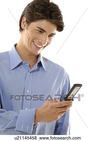 Stock Photo - Close-up of a young man text messaging with a mobile phone and smiling. Fotosearch