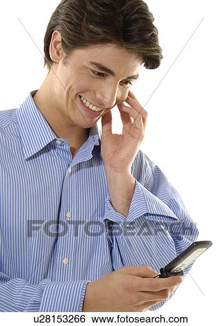 Stock Photograph - Close-up of a young man text messaging with a mobile phone and smiling. Fotosearch