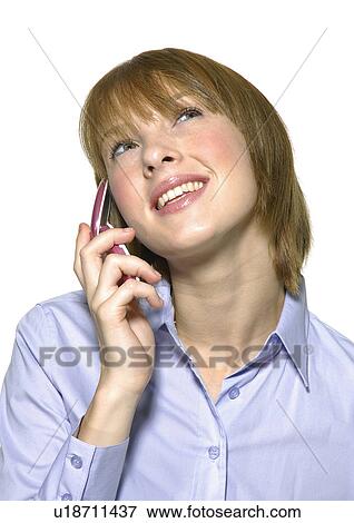 Stock Photo - Close-up of a young woman talking on a mobile phone and smiling. Fotosearch