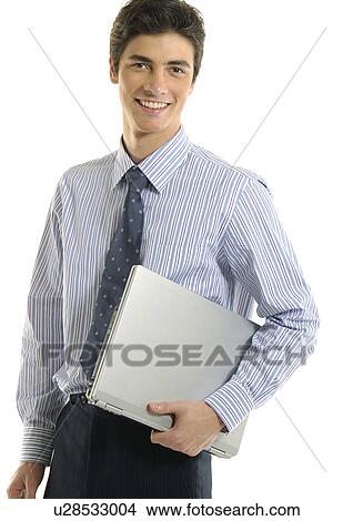 Picture - Portrait of a businessman holding a laptop and smiling. Fotosearch