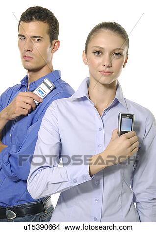Picture - Portrait of a young couple holding their mobile phones. Fotosearch