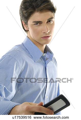 Stock Photograph - Portrait of a young man holding a mobile phone. Fotosearch