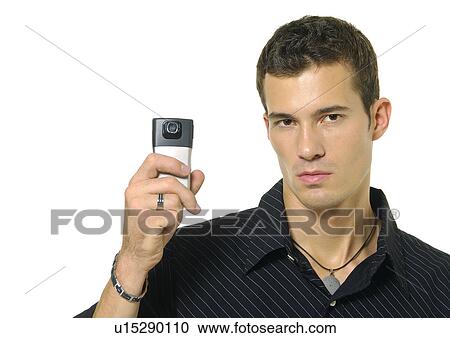 Stock Image - Portrait of a young man showing a mobile phone. Fotosearch