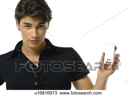 Stock Image - Portrait of a young man showing a mobile phone. Fotosearch
