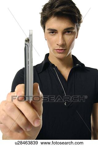 Stock Photo - Portrait of a young man showing a mobile phone. Fotosearch