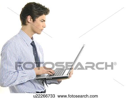 Stock Image - Side profile of a businessman using a laptop. Fotosearch