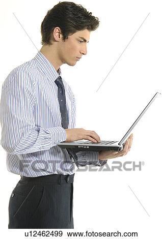 Stock Photo - Side profile of a businessman using a laptop. Fotosearch
