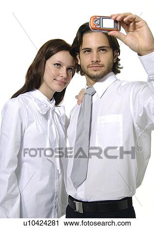 Young couple taking a picture of themselves with a mobile phone View Large Photo Image Stock Image - Young couple taking a picture of themselves with a mobile phone. Fotosearch