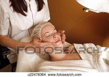 Picture - Woman having a facial treatment at a spa. Fotosearch