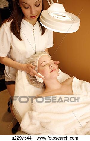 Stock Image - Woman having a facial treatment at a spa. Fotosearch