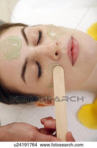 Picture - Woman having a facial treatment in a spa. Fotosearch