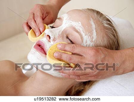 Stock Image - Woman having a facial treatment in a spa. Fotosearch