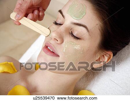 Stock Image - Woman having a facial treatment in a spa. Fotosearch