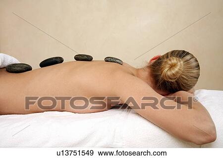 Young woman enjoying a hot stone massage View Large Photo Image Stock Photo - Young woman enjoying a hot stone massage. Fotosearch