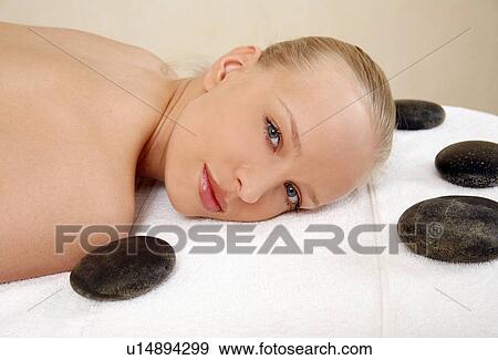 Young woman enjoying a hot stone massage View Large Photo Image Stock Photo - Young woman enjoying a hot stone massage. Fotosearch