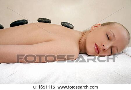 Young woman enjoying a hot stone massage View Large Photo Image Stock Photography - Young woman enjoying a hot stone massage. Fotosearch