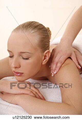 Stock Image - Young woman enjoying a massage . Fotosearch