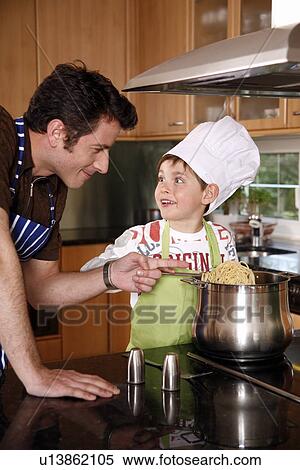 Stock Photography - Father and son cooking spaghetti. Fotosearch