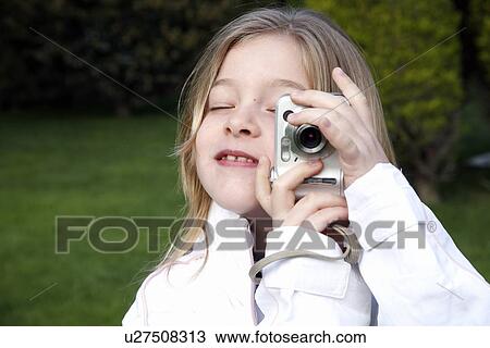 Stock Image - Little girl holding a camera. Fotosearch