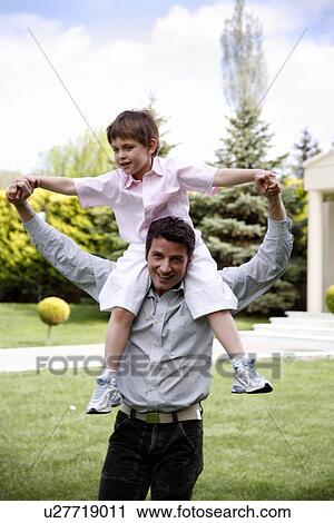Man carrying a little boy on his shoulders View Large Photo Image Stock Image - Man carrying a little boy on his shoulders. Fotosearch