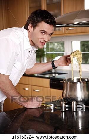 Picture - Man cooking spaghetti. Fotosearch