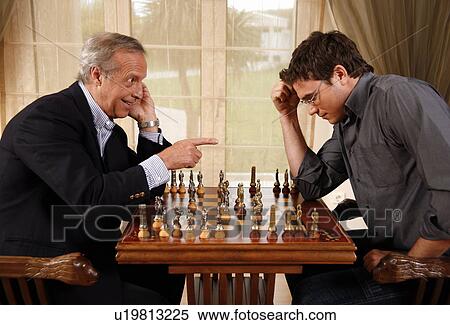 Stock Photography - Mature man and younger man playing chess. Fotosearch