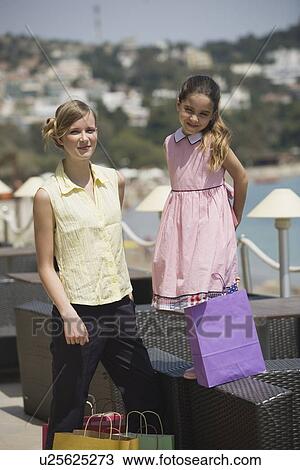 Stock Image - Mother and daughter with shopping bags. Fotosearch
