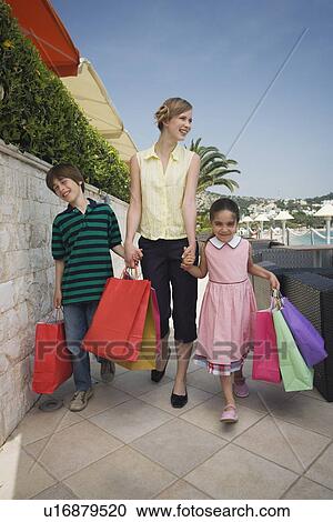 Stock Image - Mother and two children with shopping bags. Fotosearch
