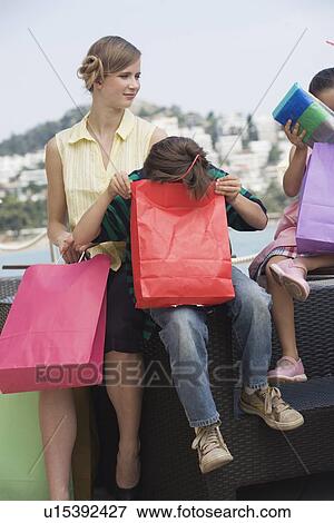 Mother and two children with shopping bags View Large Photo Image Stock Photo - Mother and two children with shopping bags. Fotosearch