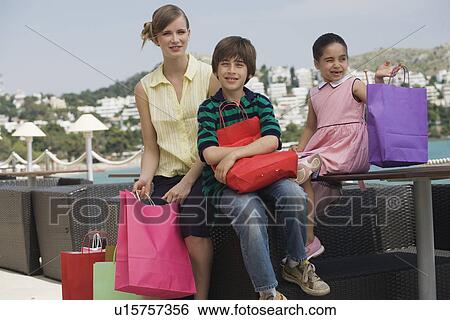 Mother and two children with shopping bags View Large Photo Image Stock Photograph - Mother and two children with shopping bags. Fotosearch