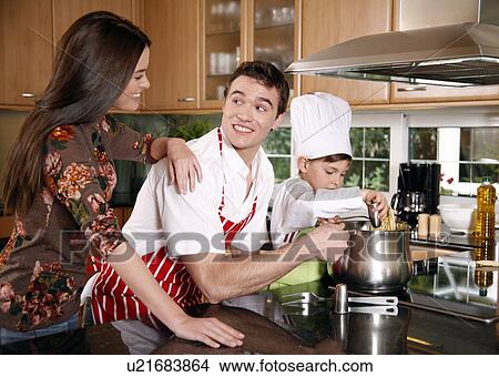 Picture - Parents and son cooking spaghetti. Fotosearch