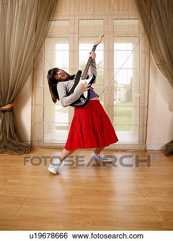 Stock Photograph - Teenage girl playing the guitar. Fotosearch