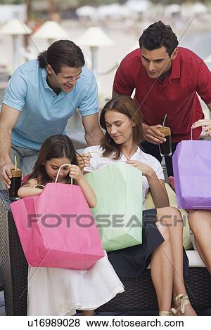 Stock Photo - Two couples and child with shopping bags. Fotosearch