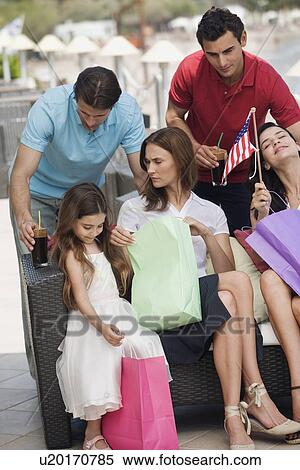 Stock Photography - Two couples and child with shopping bags. Fotosearch