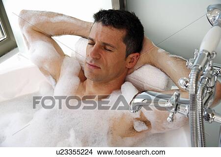 Picture - Man relaxing in bathtub with bubbles. Fotosearch