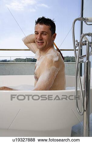 Stock Photo - Man relaxing in bathtub with bubbles. Fotosearch
