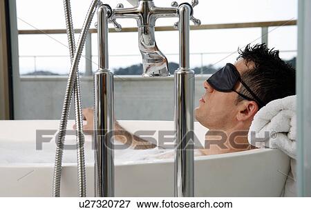 Stock Photo - Man relaxing in bathtub with bubbles. Fotosearch
