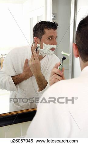 Stock Photography - Man shaving in front of mirror. Fotosearch