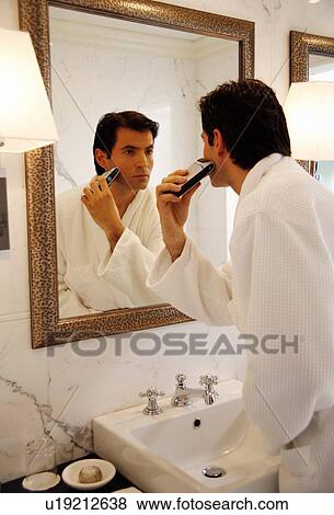 Stock Photo - Man shaving in the bathroom mirror. Fotosearch