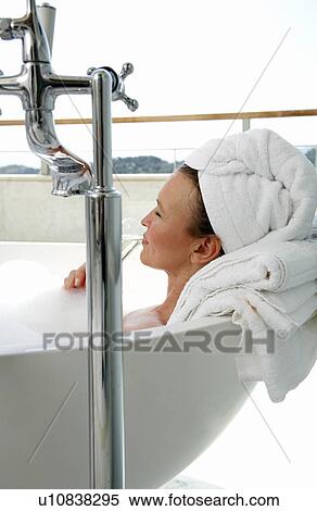 Stock Photography - Mature woman enjoying bubble bath. Fotosearch