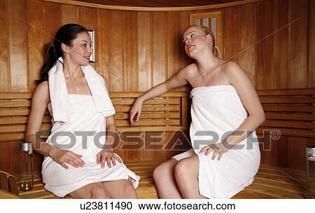 Stock Image - Two young women enjoying a sauna. Fotosearch