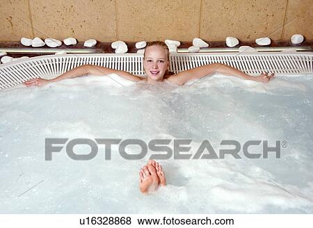 Stock Photo - Young woman in jacuzzi at a spa. Fotosearch