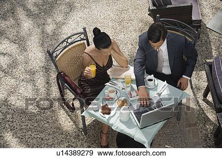 Stock Photo - Business couple in garden cafe. Fotosearch