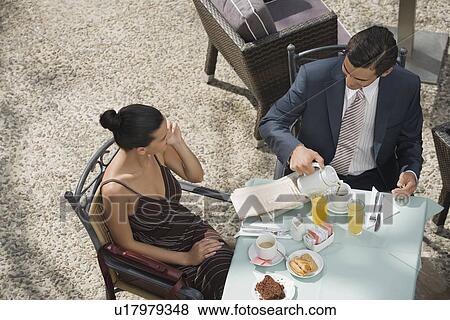 Stock Photo - Business couple in garden cafe. Fotosearch