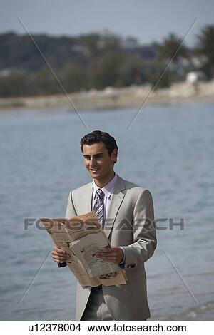 Picture - Businessman on beach with a newspaper. Fotosearch