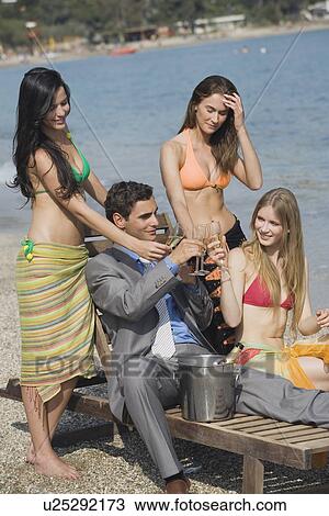 Businessman on beach with three women View Large Photo Image Stock Image - Businessman on beach with three women. Fotosearch
