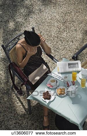 Businesswoman having breakfast in garden cafe View Large Photo Image Stock Photo - Businesswoman having breakfast in garden cafe. Fotosearch