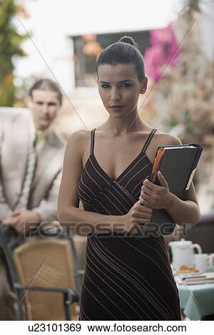 Stock Photo - Businesswoman in garden with businessman in background. Fotosearch