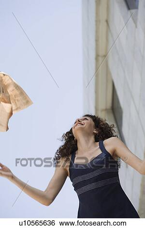Stock Photograph - Happy businesswoman throwing newspaper in the air. Fotosearch